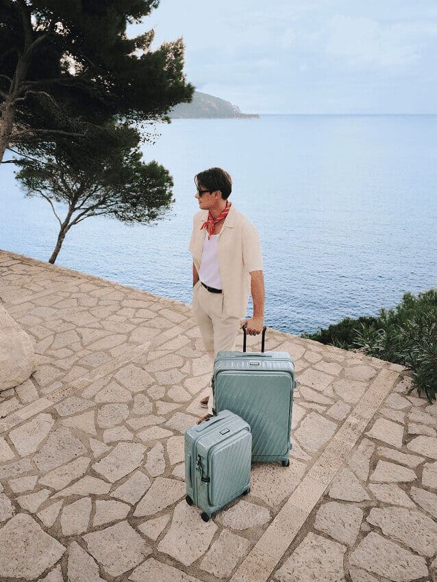 Traveler standing near the sea with suitcase